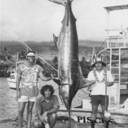 Captain Bud with blue marlin and deckhand Steven, kneeling